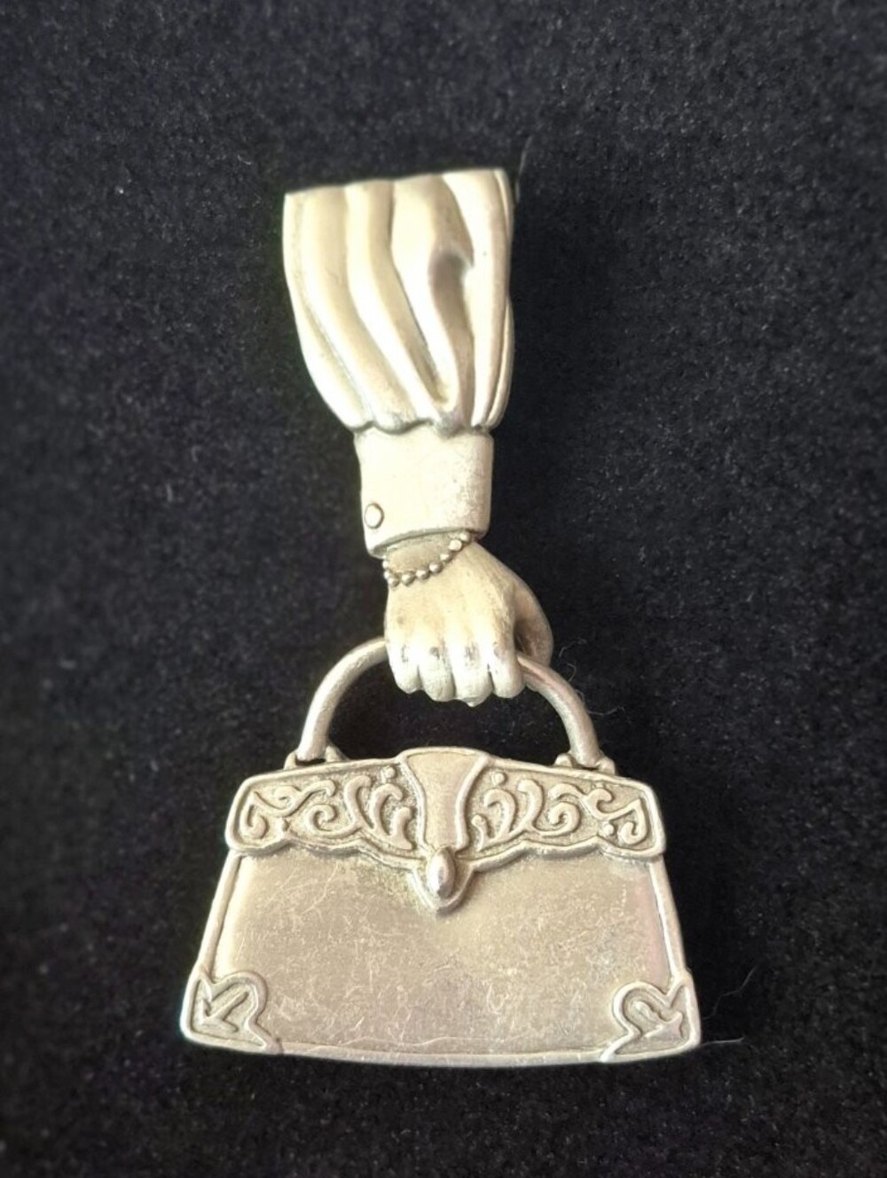 Vintage JJ (Jonette Jewelry) pewter brooch featuring a hand holding a Handbag